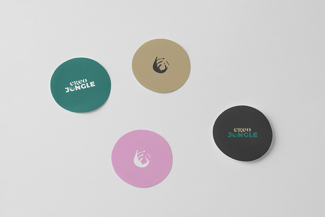 naklejki w kolorach marki CreoJungle z różnymi rodzajami logo - wersja jednokolorowa, sygnet, na czarnym tle