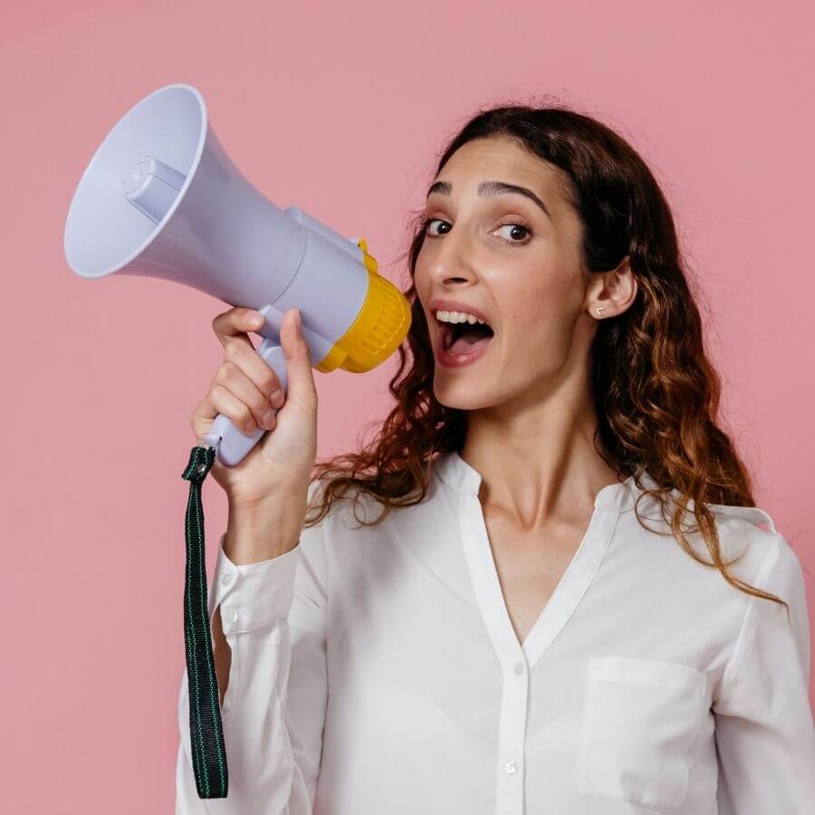 co to jest CTA? Młoda dziewczyna krzycząca do megafonu, na różowym tle